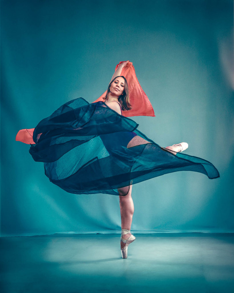 Danseuse tournant avec des tissus bleus et orange